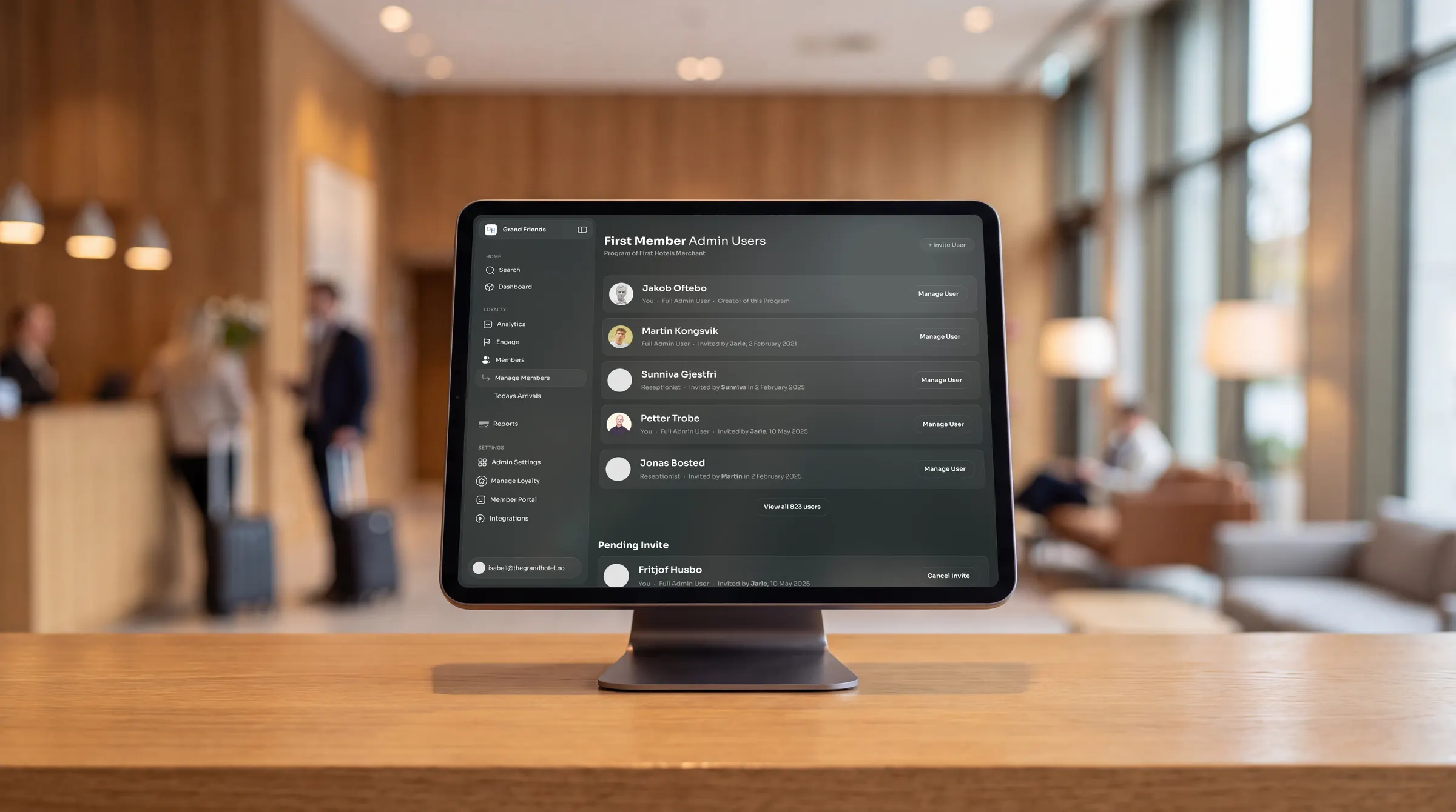 The Loyco Admin Portal on a tablet at a hotel front desk, showing the admin user list
